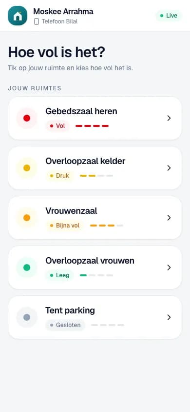 Een vrijwilliger zet op zijn gsm hoe vol de gebedsruimtes zijn